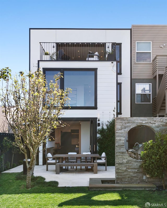 back of house with a balcony and a patio area