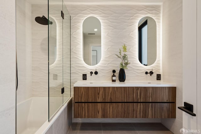 bathroom with enclosed tub / shower combo, vanity, and tile patterned flooring