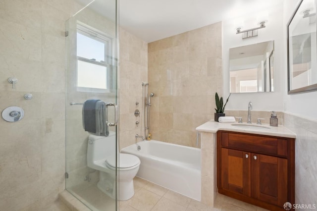 full bath with tile patterned flooring, tile walls, vanity, and toilet