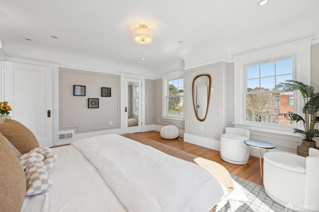 bedroom with baseboards, visible vents, wood finished floors, and recessed lighting