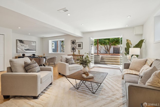 living area with recessed lighting, visible vents, plenty of natural light, and light wood-style flooring