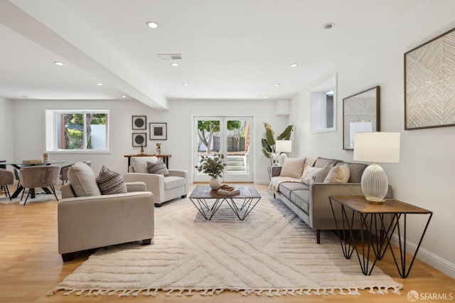 living room featuring light wood finished floors, baseboards, a wealth of natural light, and recessed lighting