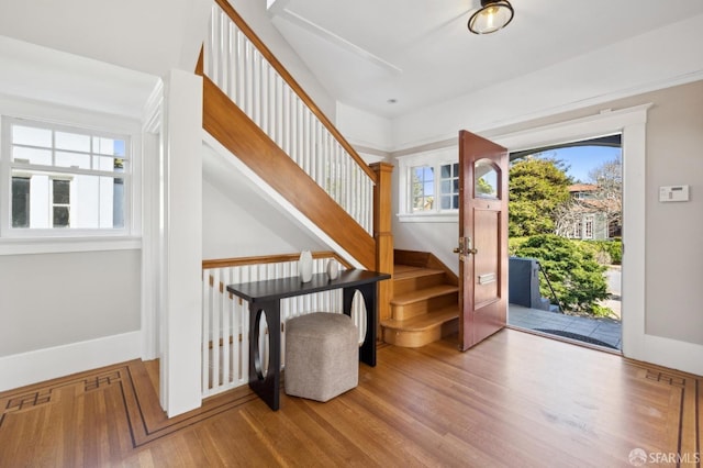 entrance foyer with stairs, baseboards, and wood finished floors