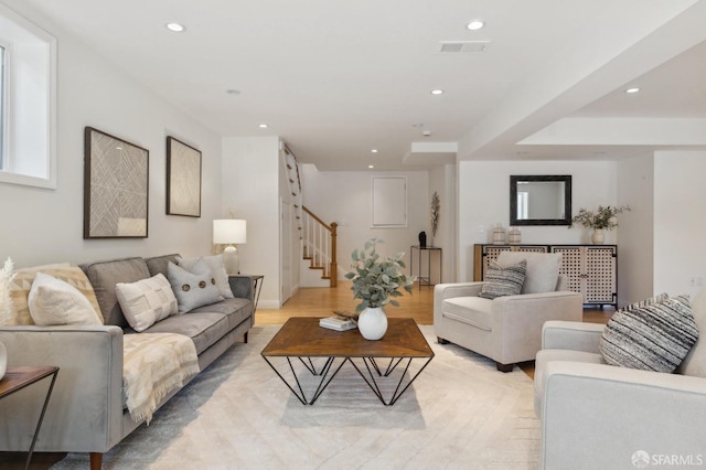 living area featuring recessed lighting, visible vents, light wood-style flooring, and stairs