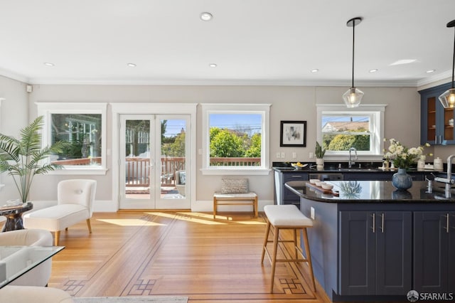 kitchen featuring recessed lighting, a sink, glass insert cabinets, and crown molding