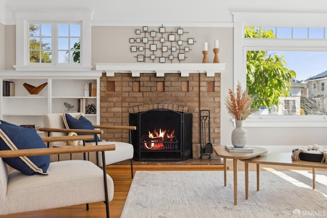 sitting room featuring plenty of natural light, a fireplace, and wood finished floors