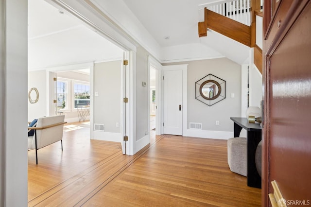 entrance foyer with light wood finished floors, baseboards, and visible vents