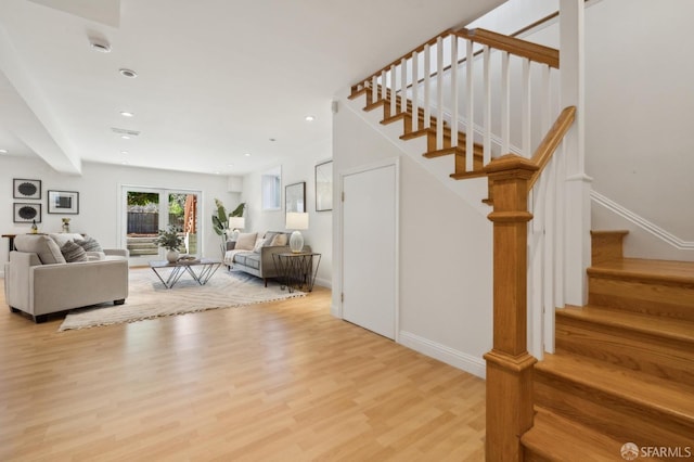 living area featuring stairs, baseboards, wood finished floors, and recessed lighting