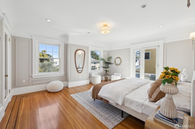 bedroom featuring access to outside, multiple windows, wood finished floors, and recessed lighting