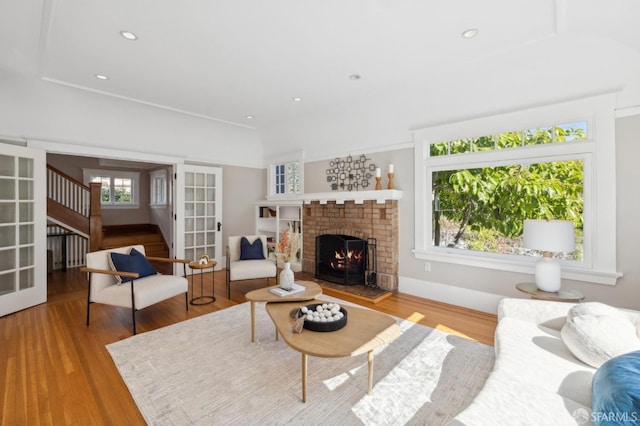 living area featuring french doors, a brick fireplace, wood finished floors, and recessed lighting