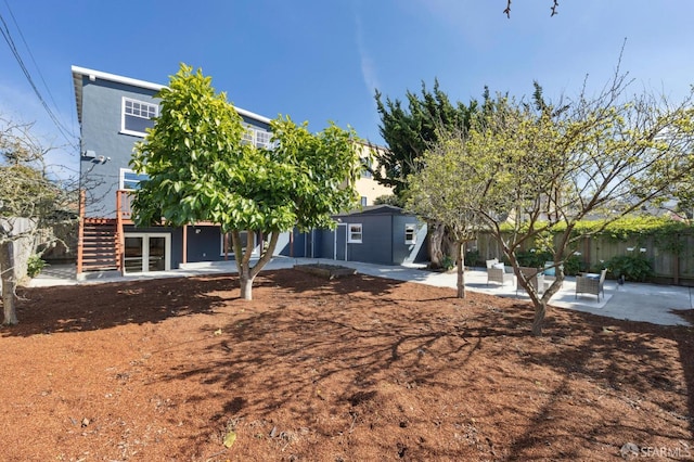 rear view of house featuring stairway, a patio area, and fence