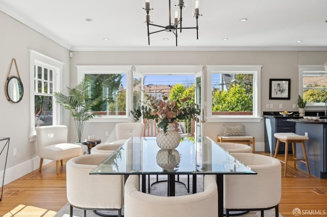 dining area featuring a notable chandelier, recessed lighting, wood finished floors, baseboards, and crown molding