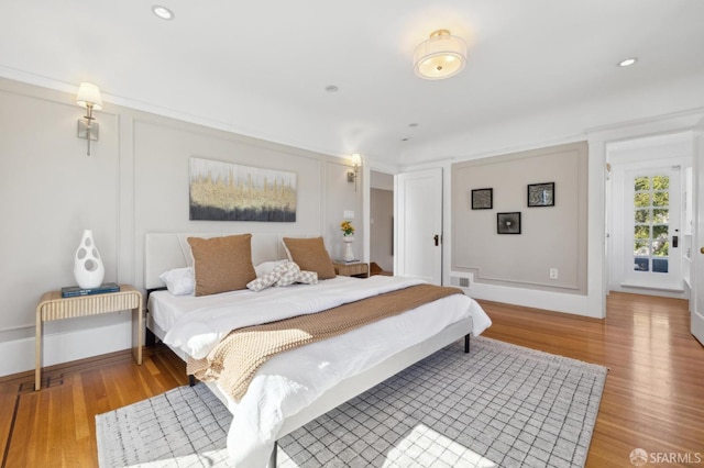 bedroom with recessed lighting, visible vents, baseboards, and wood finished floors