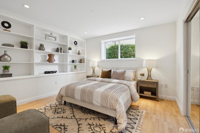 bedroom with recessed lighting, a closet, light wood-type flooring, and baseboards