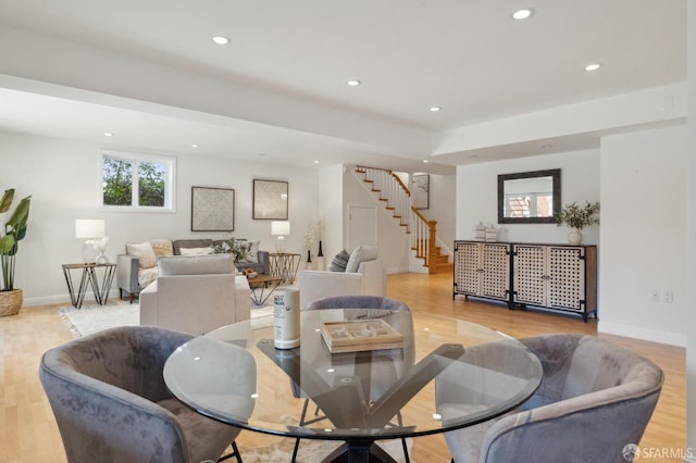 dining area with baseboards, light wood finished floors, stairway, and recessed lighting