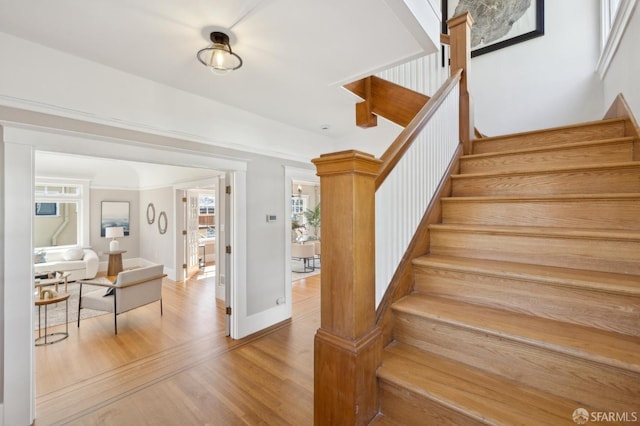 staircase with wood finished floors and baseboards