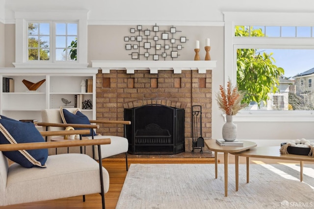 sitting room with a brick fireplace and wood finished floors