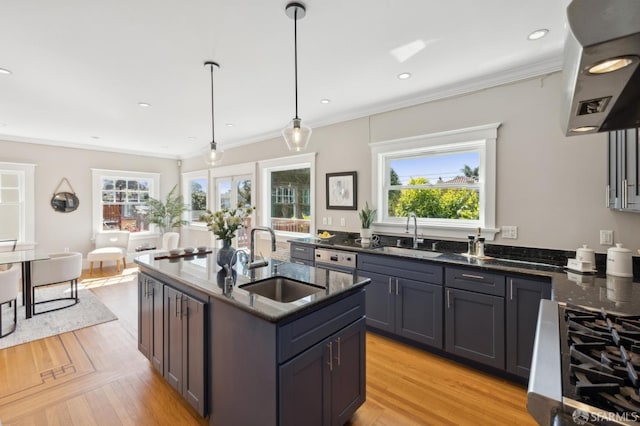 kitchen with dark stone counters, a sink, and crown molding