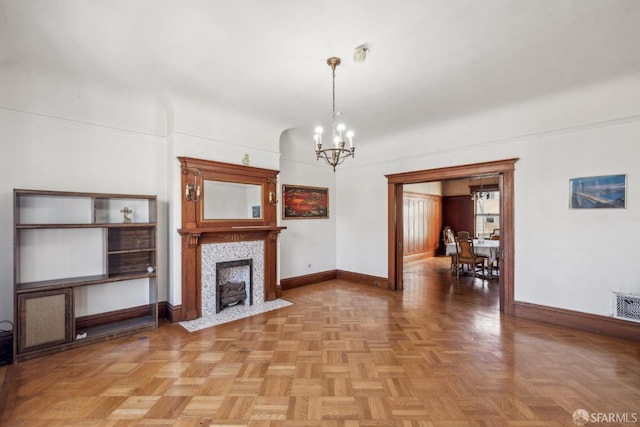 unfurnished living room featuring a chandelier, a fireplace, visible vents, and baseboards