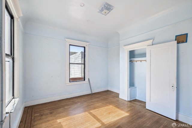 unfurnished bedroom featuring a closet, baseboards, and wood finished floors