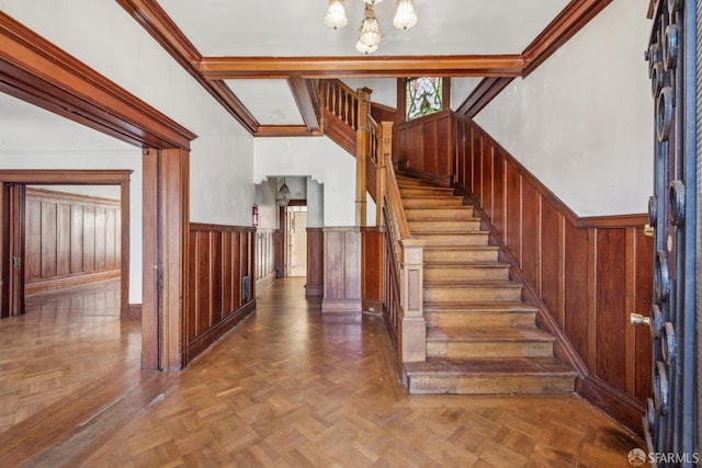 stairway featuring a wainscoted wall, wood walls, and beamed ceiling