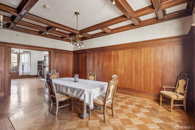 dining area featuring wood walls, coffered ceiling, beam ceiling, and a notable chandelier