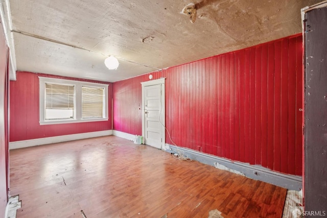 unfurnished room with baseboards and wood finished floors