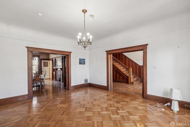 unfurnished room featuring baseboards, visible vents, and a notable chandelier