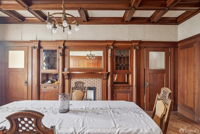 dining area featuring a chandelier, coffered ceiling, and beam ceiling