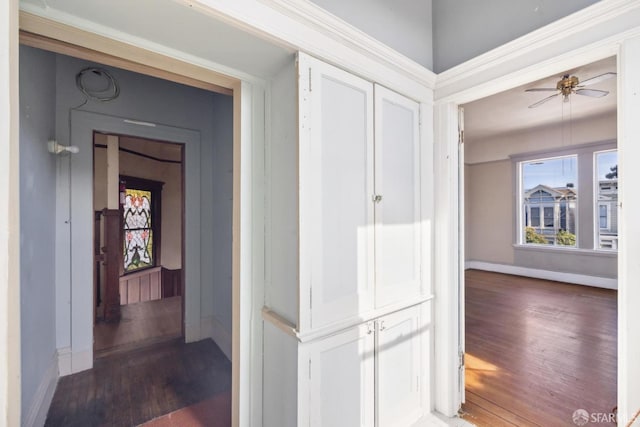 corridor with baseboards and wood finished floors