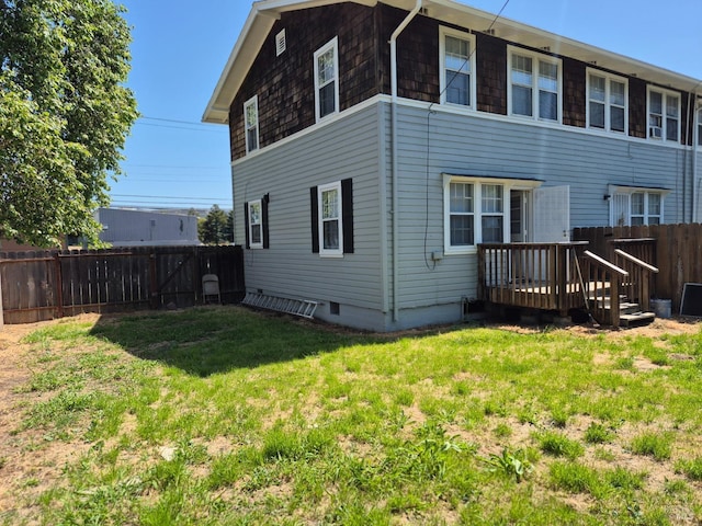 back of property featuring a yard, a deck, and a fenced backyard