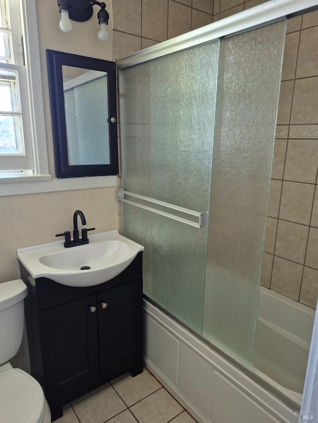 full bathroom featuring vanity, toilet, tile patterned flooring, and enclosed tub / shower combo