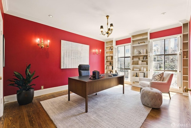 office area with crown molding, baseboards, a notable chandelier, and wood finished floors