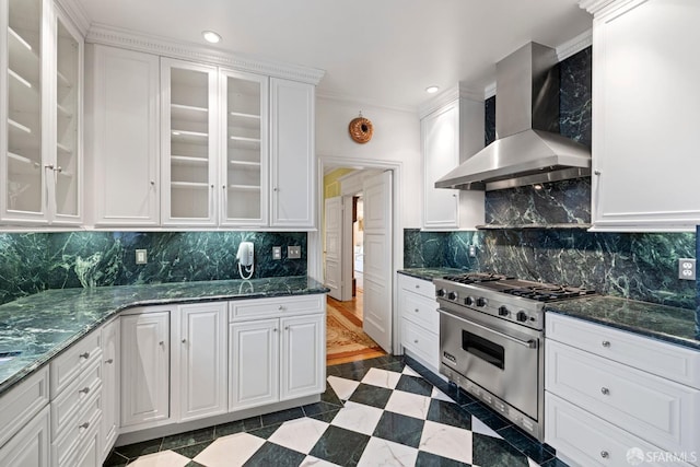 kitchen with white cabinets, wall chimney exhaust hood, glass insert cabinets, and high end stainless steel range