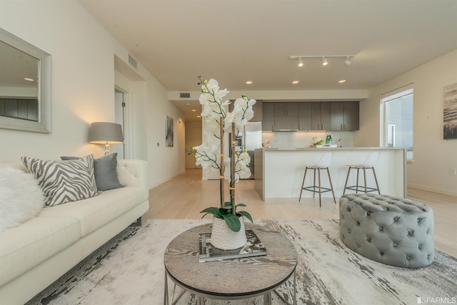 living area featuring light wood-style floors, recessed lighting, and visible vents