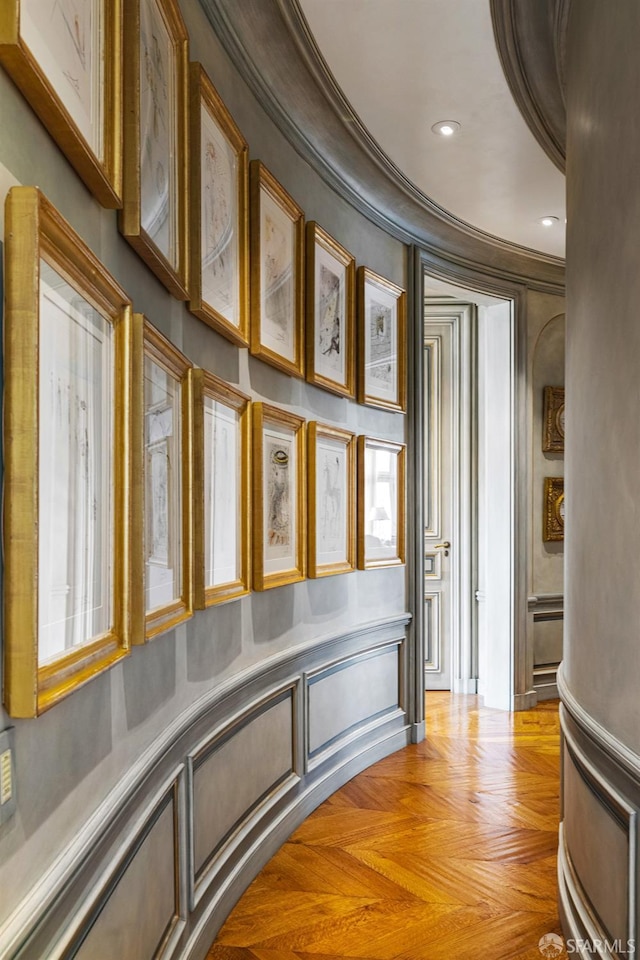 hallway with crown molding and light parquet floors