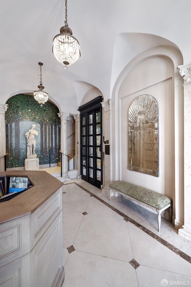 foyer entrance featuring ornate columns and an inviting chandelier