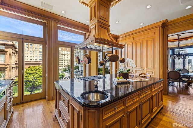 kitchen featuring a kitchen island, dark stone countertops, light hardwood / wood-style floors, and a healthy amount of sunlight