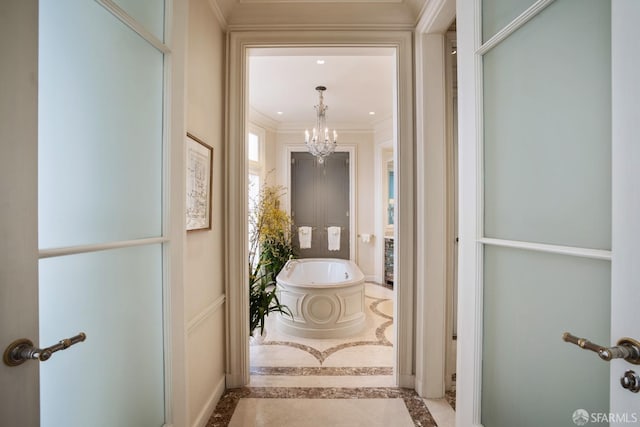 bathroom with a washtub, ornamental molding, and a chandelier