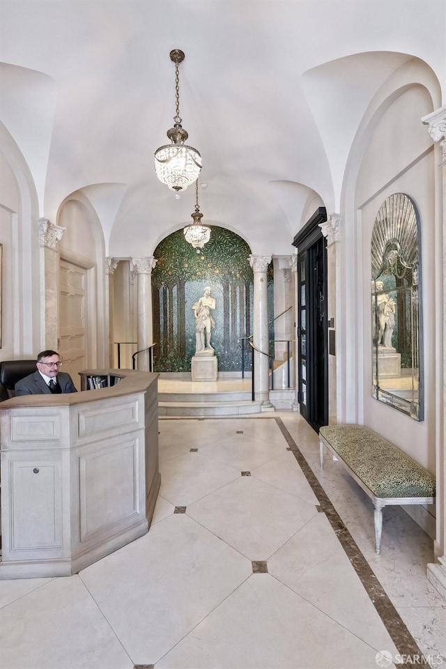 interior space featuring ornate columns and a notable chandelier