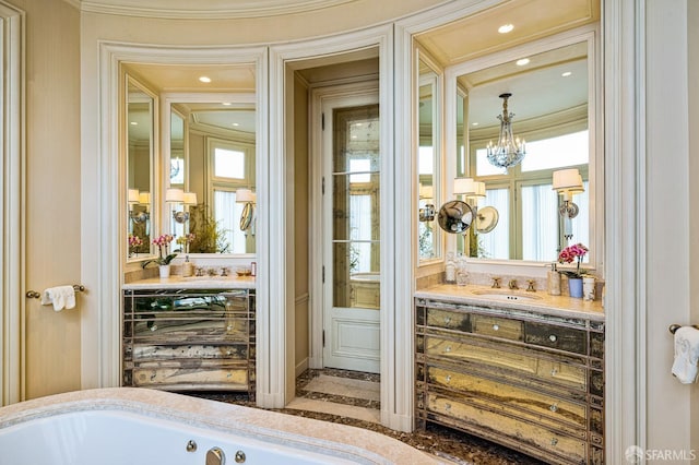 bathroom with a notable chandelier, vanity, crown molding, and a washtub