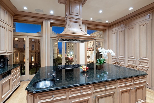 kitchen featuring a kitchen island, light wood-type flooring, sink, and dark stone counters