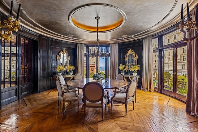 dining room with a tray ceiling, french doors, a notable chandelier, and parquet flooring