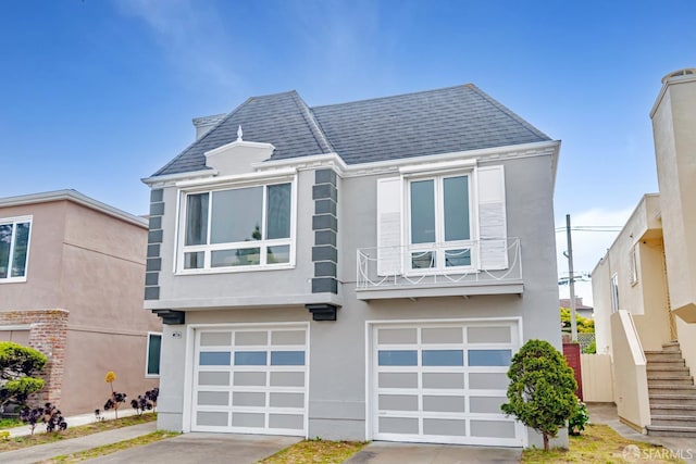 view of front of home featuring a garage, stucco siding, driveway, and stairs