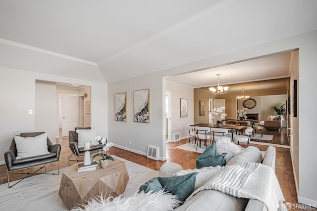 living room featuring baseboards, a chandelier, and ornamental molding