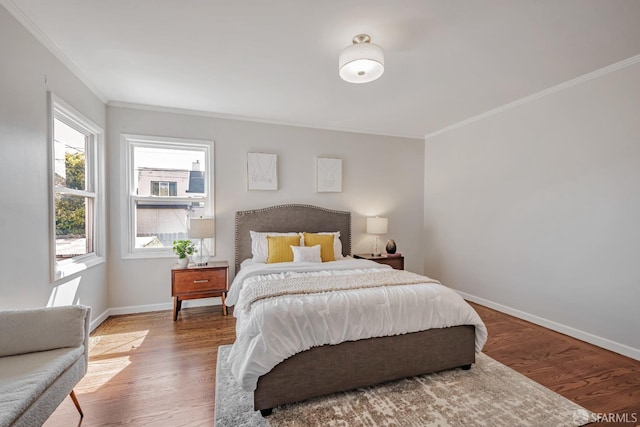 bedroom featuring crown molding, baseboards, and wood finished floors