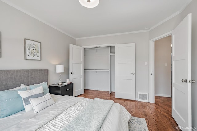bedroom featuring ornamental molding, wood finished floors, a closet, and baseboards