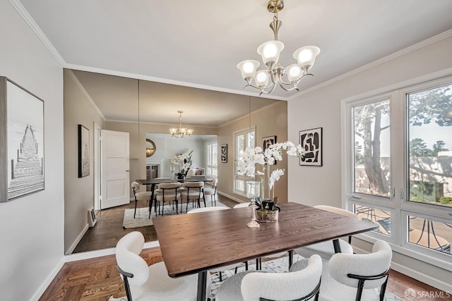 dining room with a chandelier, healthy amount of natural light, baseboards, and ornamental molding