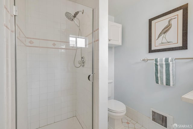 full bath featuring a shower stall, toilet, and tile patterned floors