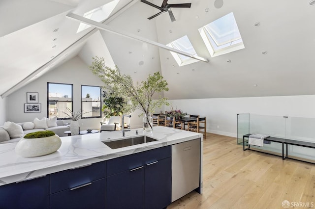 kitchen featuring light stone countertops, sink, a wealth of natural light, and lofted ceiling with skylight